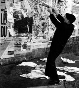 Jacques Villegle tearing up a poster (1961). Photograph by Shunk-Kender