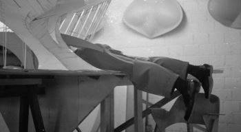 Eero Saarinen's legs hanging out of a model in his office of the Trans World Airlines Terminal for Idlewild (now JFK) International Airport (c. 1958)