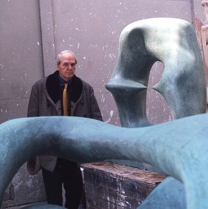 Henry Moore standing next to his sculpture Working Model for <i>Oval with Points</i> (1975)