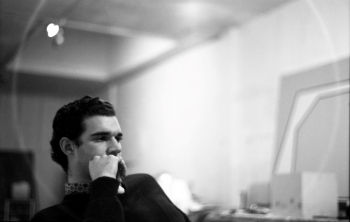 Larry Bell in studio in 1960 with skylight and <i>Lil' Orphan Annie</i> in background. Photographer unknown, courtesy of the artist.