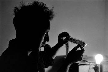 Frank looking at negatives in California while photographing <i>The Americans</i> (1956)