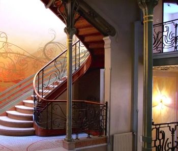 The spiraling staircase of Victor Horta's Hôtel Tassel (1893) is echoed in the patterns of the wall, floor, and railings.