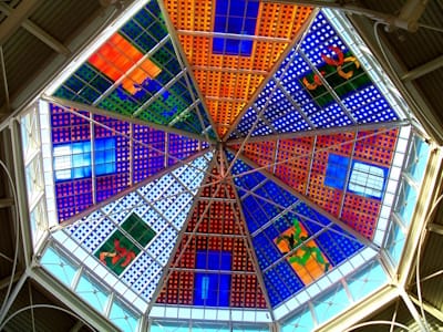 British artist Brian Clarke offers a contemporary spin on stained glass, often with abstract and geometric designs, in works like his stained glass ceiling in the Spindles Shopping Centre, Oldham, Lancashire (1990-93).