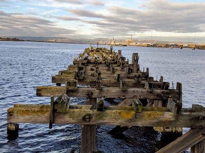 The final figure of Gormley's <i>6 TIMES</i> is just visible at the end of the derelict pier, looking out over Leith Docks in Scotland. This form marks the end point of the piece which starts in central Edinburgh, with figures arranged along the Waters of Leith, a river running through the city and out to the sea. Parallels can be drawn between the natural and human journeys of the work, as the ebb and flow of the river underscores the progression of human figures along it.