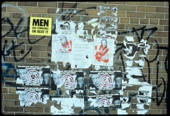 Photograph of Gran Fury's sticker and flyers on a public wall, New York City, 1988