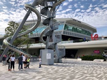 Street level view of the 93-foot glass-and-steel slide tower at Miami's Aventura Mall. Höller's slides break down boundaries between play and art (inside <i>and</i> outside the gallery space).