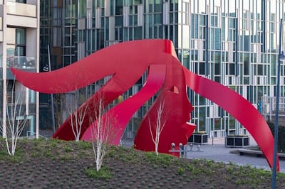 <i>Head in the Wind</i> (2019), Greenwich Peninsula. Inspired by the tides, visitors and residents are encouraged to observe the red painted-steel piece from different perspectives and to catch different aspects of the sculpture.