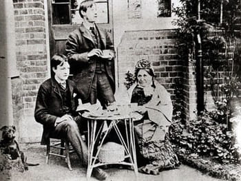 Mackmurdo (standing), with his mother and his architectural pupil Herbert Horne, in the garden of <i>Halcyon</i>, a home Mackmurdo built for his mother in Bush Hill Park in 1876.