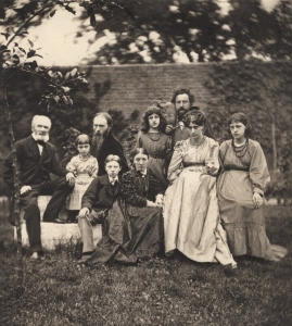 The Morris and Burne-Jones families at The Grange, the West London home of Burne-Jones. Morris stands to the right behind his wife and two daughters, while Burne-Jones sits at center-left with his wife, children, and father to the far left. The photograph by Frederick Hollyer (1874) is held at the National Portrait Gallery.