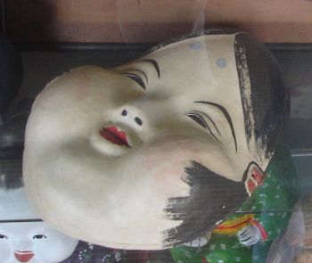 In Japanese culture, Otafuku (also known as Okame) masks represent the female half of a traditional Japanese Kyogen theater pair. Otafuku is a symbol of happiness and good luck, and is always depicted with full cheeks and joyful eyes.
