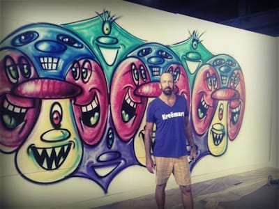 American Neo-Pop artist Kenny Scharf (pictured here with a mural he painted in 2010) has, like many Neo-Pop artists, been heavily influenced by the graffiti aesthetic, and been involved in graffiti painting since the 1980s.