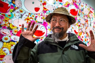 Japanese artist Takashi Murakami (pictured here in front of his enormous 2009 painting <i>Lots, Lots of Kaikai and Kiki</i>) coined the term “Superflat” in 2000.
