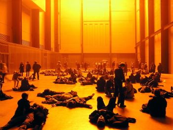 Icelandic artist Olafur Eliasson created <i>The Weather Project</i> (2003), using a semi-circle of 200 mono-frequency bulbs, reflected on the mirrored ceiling, in the Turbine Hall of the Tate Modern, London. His aim was to create an environment, in which audiences would be encouraged to participate by spending time in the space, sitting or relaxing on their backs, and interacting with one another in the artificial atmosphere.