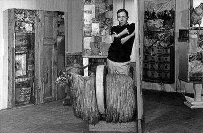 Rauschenberg in his Front Street studio, New York, surrounded by several of his combines, including <i>Interview</i> (1955), <i>Untitled</i> (c. 1954), second state of <i>Monogram</i> (1955-59; second state 1956-58), <i>Bed</i> (1955), and <i>Odalisk</i> (1955/1958) (1958). Photo by Kay Harris