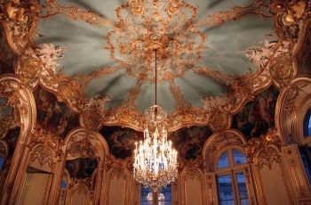 This photograph shows the ornate gilded ceiling of Charles-Joseph Natoire and Germain Boffrand's La Salon de la Princesse (1735-1740).