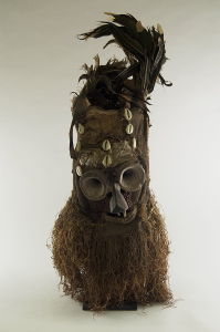 This <i>Fiber Mask with Conical Eyes (Batwape)</i> (late 19<sup>th</sup> or early 20<sup>th</sup> century) incorporates burlap, cowrie shells, and raffia.