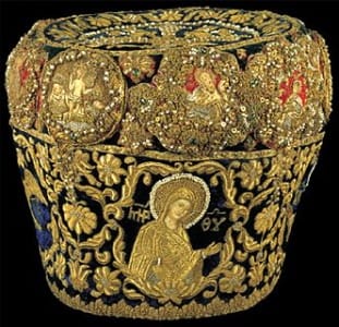 This Eastern Orthodox mitre, a headdress worn by bishops and other Christian leaders, ornately depicts saints, crosses, and other Christian symbols with gold thread and jeweled embellishments.