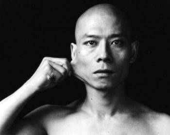 Zhang performing <i>Skin</i> (1997), wherein he distorted his face using his hands