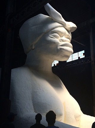 A side view of the monumental work <i>A Subtlety, or the Marvelous Sugar Baby an Homage to the unpaid and overworked Artisans who have refined our Sweet tastes from the cane fields to the Kitchens of the New World on the Occasion of the demolition of the Domino Sugar Refining Plant</i> (2014)